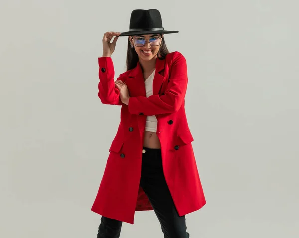 Счастливая Случайная Женщина Очках Регулируя Шляпу Улыбаясь Время Ношения Красного — стоковое фото