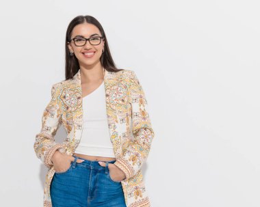 Gri arka planda el ele tutuşup gülümseyen, gözlüklü güzel bir kadın. 