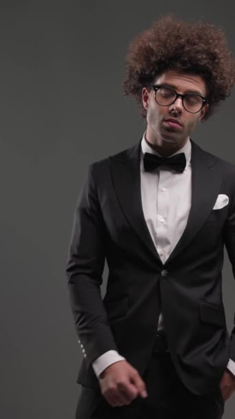 Elegancki Młodzieniec Okularach Czarnym Smokingu Wykonujący Gest Milczenia Obracający Się — Wideo stockowe