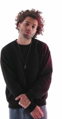 Siyah kapüşonlu havalı adamın masum rolü yaptığı, arkasına yaslandığı ve gri arka planda kendine güvenen bir şekilde poz verdiği dikey moda videosu.