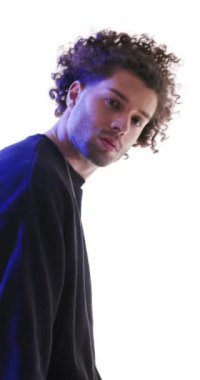 Siyah kapüşonlu seksi bir adamın yan görünüşü. Gri arka planda polis ışıkları açıkken kendinden emin ve ileriye bakıyor.