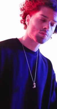 Siyah kapüşonlu seksi adam yürüyor, arkasını dönüyor, arkasını kolluyor ve polis ışıkları açıkken ileriye bakıyor.