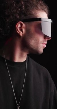 Gelecekçi siber güneş gözlüklü havalı modelin dikey videosu. Siyah arka planda polis ışıkları var.