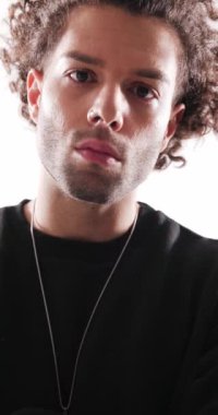 Siyah kapüşonlu ciddi sıradan bir adamın gri arka planı merak ederken ısrarla ileriye baktığı videoyu kapat.