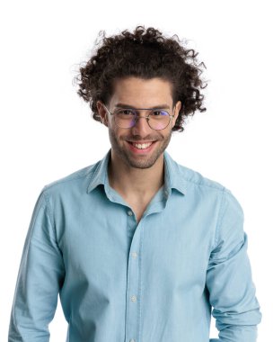 Kıvırcık uzun saçlı, gözlüklü ve beyaz arka planda mavi gömlekli mutlu genç adama yakın durun.