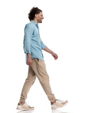 Mavi gömlekli ve gözlüklü mutlu bir adam izole arka planda hareket ediyor.