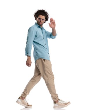 Beyaz arka planda elini sallayan öfkeli, sıradan bir adamın yan görüntüsü.
