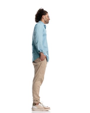 Rahat, sıradan bir adam, elleri cebinde beyaz arka planda sırada bekliyor.