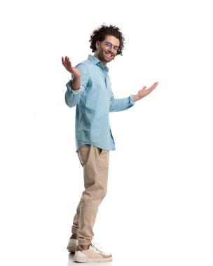 Sıradan bir adamın hoş geldin jesti yapması ve beyaz arka planda dururken gülümsemesi.