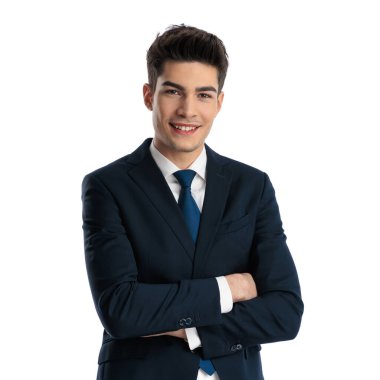 Lacivert takımlı mutlu iş adamı kollarını kavuşturup beyaz arka planda gülümsüyor. 