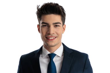 Zarif takım elbiseli yakışıklı esmer iş adamı beyaz arka planda kameraya bakarken mutlu ve gülümsüyor.