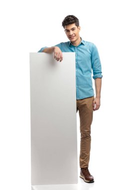 Beyaz arka planda dururken boş reklam veren mutlu sıradan bir adam.