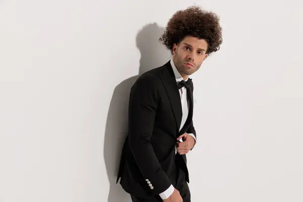 Elegant Young Businessman Looking Forward While Unbuttoning Black Tuxedo Front — Stock Photo, Image