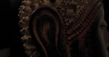 Buda 'nın parlak ustalık heykelinin karanlık arka planda dönen tacı ile dikkatli meditasyon kavramını gösteren videoyu kapat.