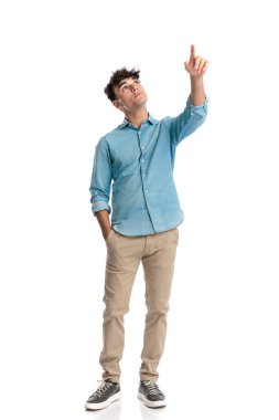 20 'li yaşlardaki tatlı bir öğrenci el ele tutuşmuş ve beyaz arka planda dururken uçağı gökyüzünde gösteriyor.