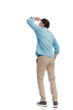 Arka planda kot gömlekli genç adam el ele tutuşuyor ve beyaz arka planda gökyüzünde uçağı seyrediyor.