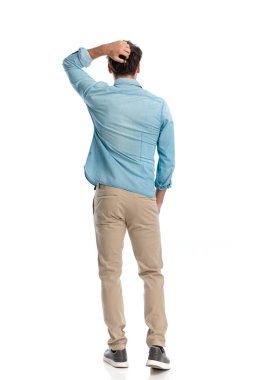 Kafasını kaşıyan ve zor sorunları düşünen elleri ceplerinde duran kafası karışık genç bir adamın arka planı.