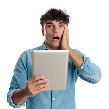 Şaşkınlık içindeki genç bir öğrenci, beyaz arka plandaki yüzlere dokunarak, elinde bir masa tutarak aldığı notu öğreniyor.