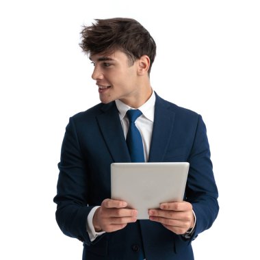 Tableti beyaz arkaplan önünde tutarken gülümseyen mutlu, zarif iş adamının portresi