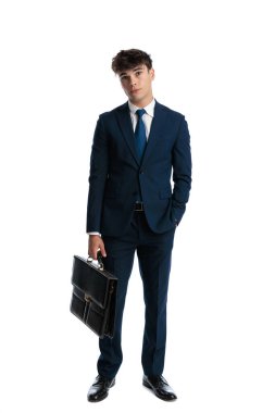 Lacivert takım elbiseli seksi genç işletme öğrencisi elinde bavulla beyaz arka planda el ele poz veriyor.