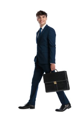 Mavi takım elbiseli gülümseyen genç bir adam el ele yürüyor ve beyaz arka planda mutlu.