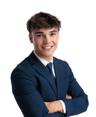 Lacivert takım elbiseli genç iş adamının portresi kollarını kavuşturup beyaz arka planda gülümsüyor.