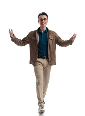 Akıllı nedensel adam beyaz arka planda öne doğru adım atarken hoş bir el hareketi yapıyor, tüm vücuduyla.