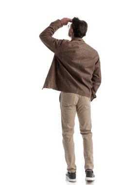 Uzaktan gözlemlemek için avucunu alnına götürürken yan yana bakan zeki sıradan bir adamın dikiz aynası.