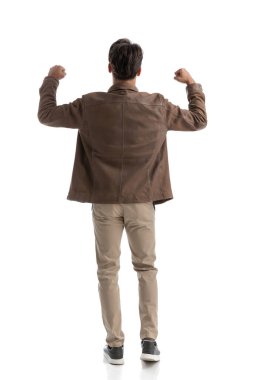 Beyaz arka planda tek başına duran ve yumruklarını havaya kaldırarak kutlama yapan genç, zeki, sıradan bir adamın arka planı.