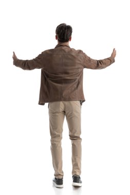 Deri ceket giyen, beyaz arka planda dururken el hareketi yapan zeki, sıradan bir adamın arka planı.