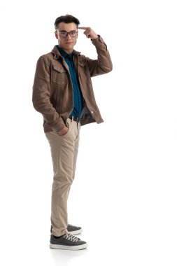 Genç, zeki, sıradan bir adam kuyrukta bekliyor. Beyaz arka planda el ele dururken parmağıyla kafasını işaret ediyor.