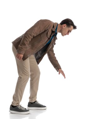 Zeki, sıradan bir adam, beyaz arka planda dururken yerden bir şey kapmak için sırada bekliyor.