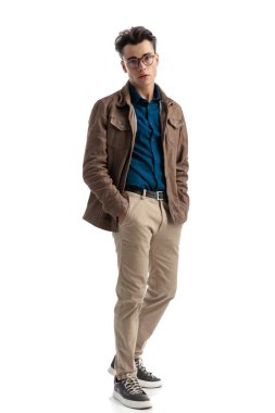 Beyaz arka planda dikilirken cebini tutan yakışıklı, zeki, gündelik bir adam. Baştan çıkarıcı bir poz veriyor.