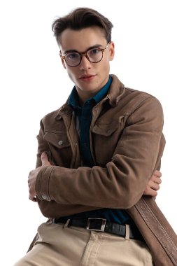 Deri ceketli yakışıklı genç adam beyaz arka planda oturan Harry Potter 'a benziyor.