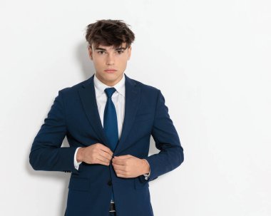 Beyaz bir duvarın yanında duran yakışıklı ve genç işadamının yakını.