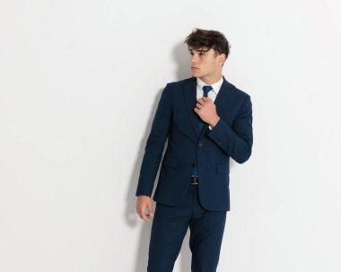 Çekici genç işadamlarına yaklaşıp donanma kravatını düzeltiyorum ve beyaz duvarın yanında dikiliyorum. 