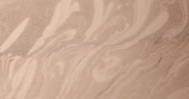 Değişik rastgele şekillerle altın ve kahverengi duvar resimleri hareket ediyor gibi görünüyor.