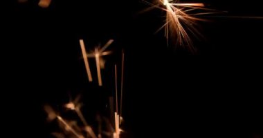 Güzel havai fişekler yeni yıl arifesini kutlarken karanlık ve karanlık gökyüzüne ışıldıyor.