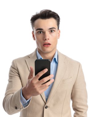 Beyaz arka planda rahatsız edici bir e-postayı okuyan, şok olmuş, zeki, sıradan bir adamın yakın çekimi.