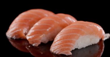 Nigiri suşisinden yapılmış pembe çiğ somon ve pilav ile otantik Japon lezzetlerine dalmak mükemmel Japon lezzeti yaratır.