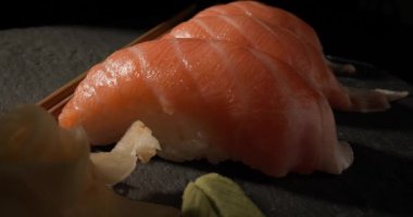 Pembe çiğ somon ve pilav ile otantik Japon lezzetlerine dalmak, nigiri sushi, harika bir tat için mükemmel denge oluşturur, wasabi ve gari ile servis edilir.