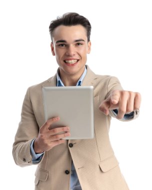 Beyaz arka planda gülümserken, kağıt tutan ve parmağıyla işaret eden akıllı sıradan bir adamın portresi.