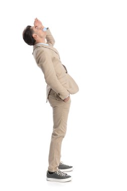 Uzaktan bakan meraklı işadamının yan görüntüsü. Cebi ve alnını tutarken.