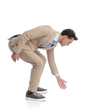 Meraklı işadamlarının yan görünüşü öne eğilip yerden bir şey almaları.