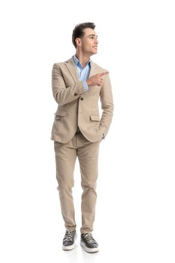 Rahat, akıllı, sıradan bir adam. Parmakla gösterip, ceplerini tutarken, tüm vücudunu gösteriyor.