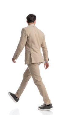 Meraklı, zeki, sıradan bir adamın beyaz arka plana basıp tam boy fotoğrafa bakması.