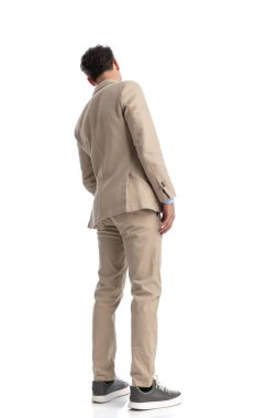 Bej takım elbiseli genç işadamlarının arka plan görüntüsü yana doğru eğiliyor ve uzun bir resim çiziyor.