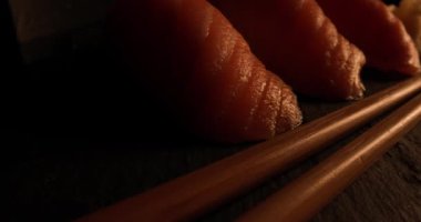 Nigiri Suşi 'ye yakın çekim karanlık bir odada servis edilir ve sonunda parlak ışık belirir.