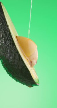 Avokado meyve ve yağının yeşil arka plandaki besin ve vitaminlerle dolu kenar görüntüsü