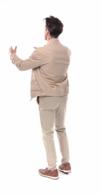 Avuç içi çırpan ve beyaz arkaplan önünde dikilirken kutlama yapan sıradan genç adamın dikey videosu